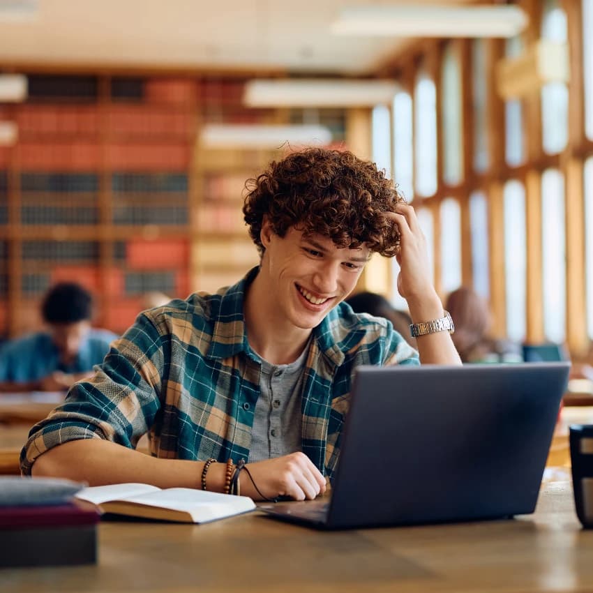 Author working on a laptop in a library